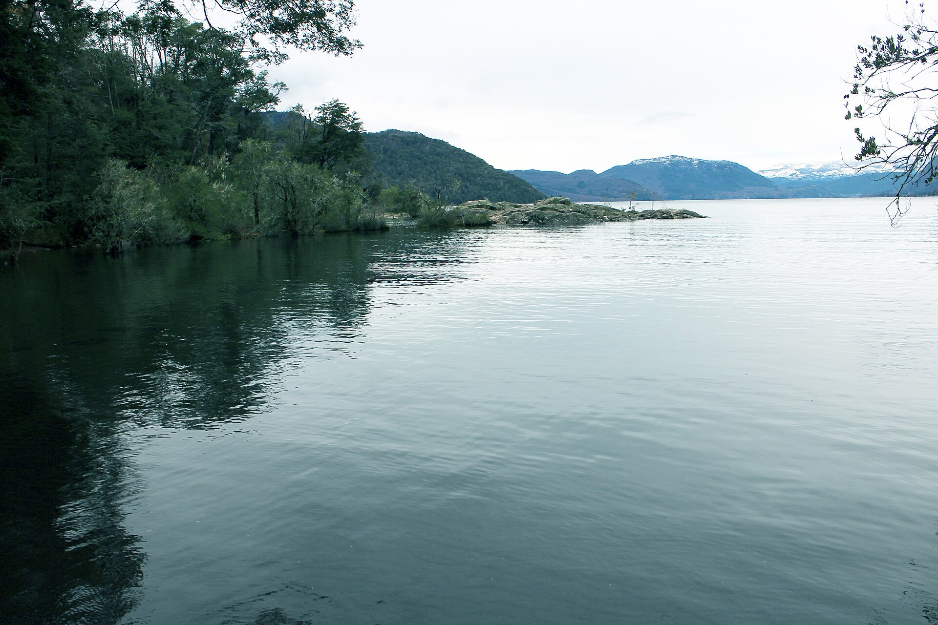 Aguas calmas de Lago Hermoso entre bosques